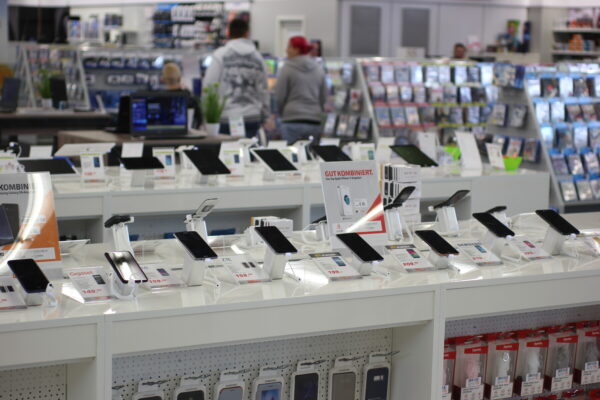 Smartphones mit Diebstahlsicherung auf Präsentationstischen im Elektronikmarkt